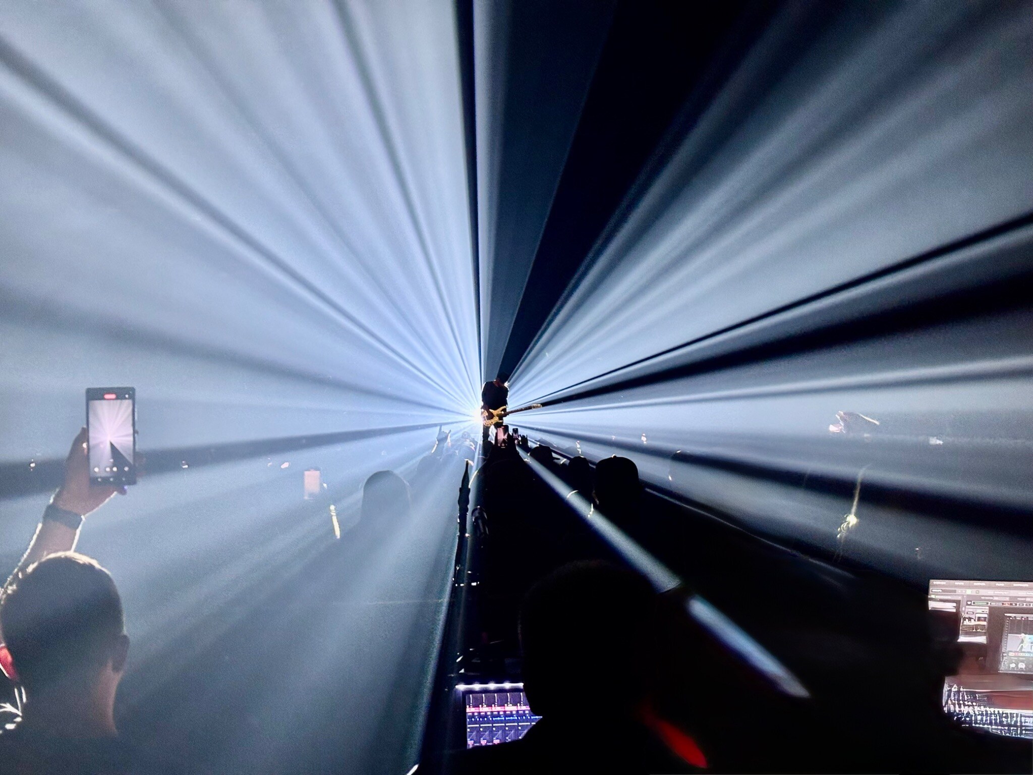 Musician framed by powerful white beams during a live concert